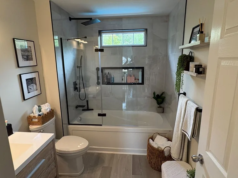 Custom tile bath and shower install with a glass panel and matte black fixtures